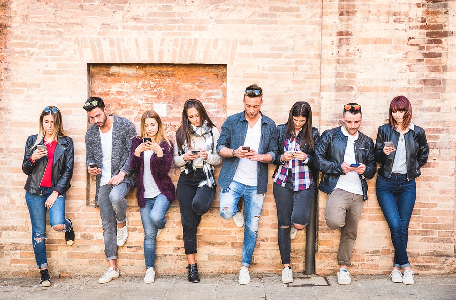 Friends group using smartphone against wall at university college backyard break - Young people addicted by mobile smart phone - Technology concept with always connected millennials - Filter image