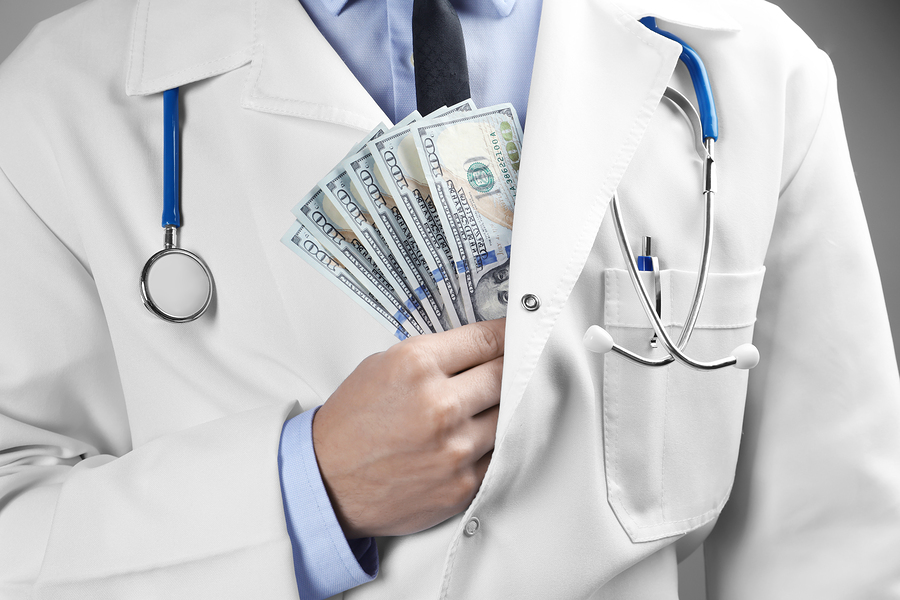 Doctor putting money in pocket, closeup. Corruption concept